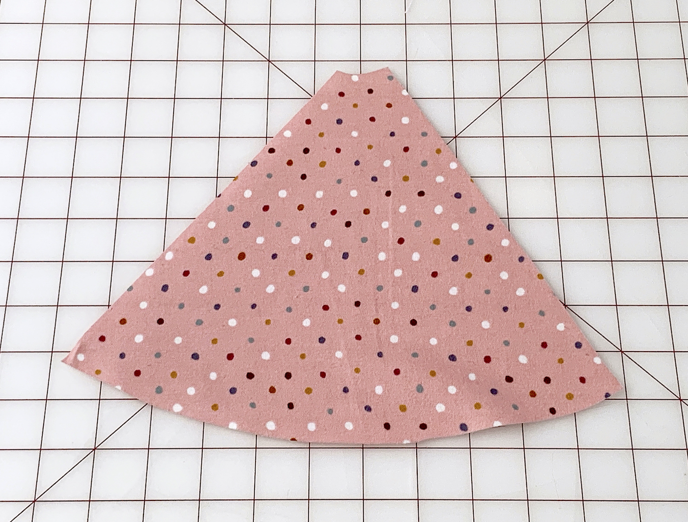 Cut polka dot flannel fabric piece laying on the cutting mat