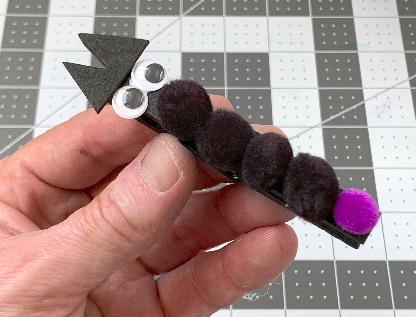 Gluing ears, eyes, and pom poms onto the clothespin