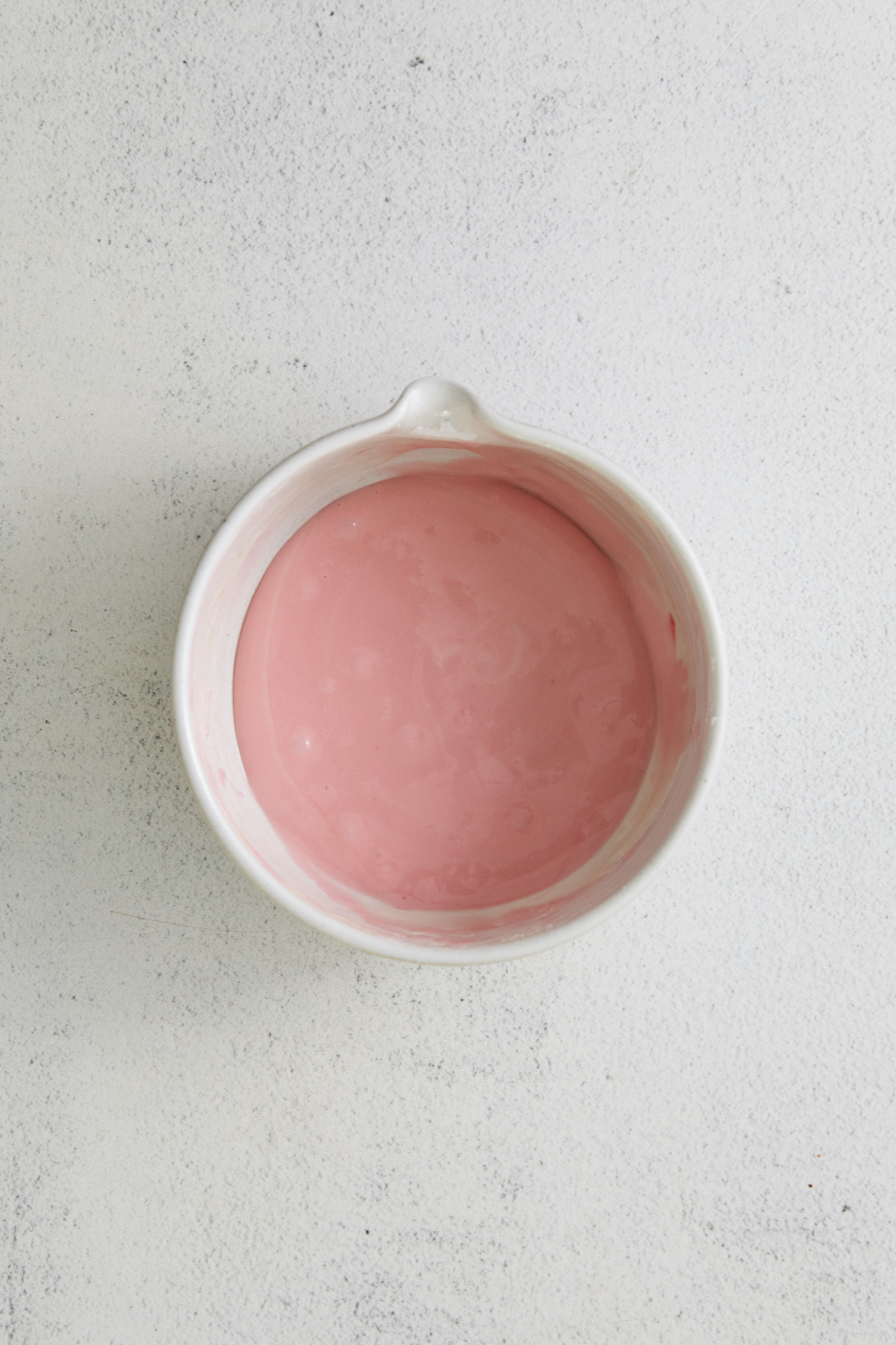 Homemade pink frosting in a bowl