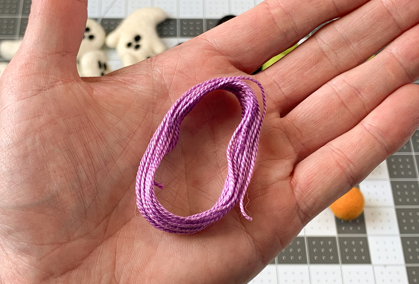Hand holding purple embroidery floss