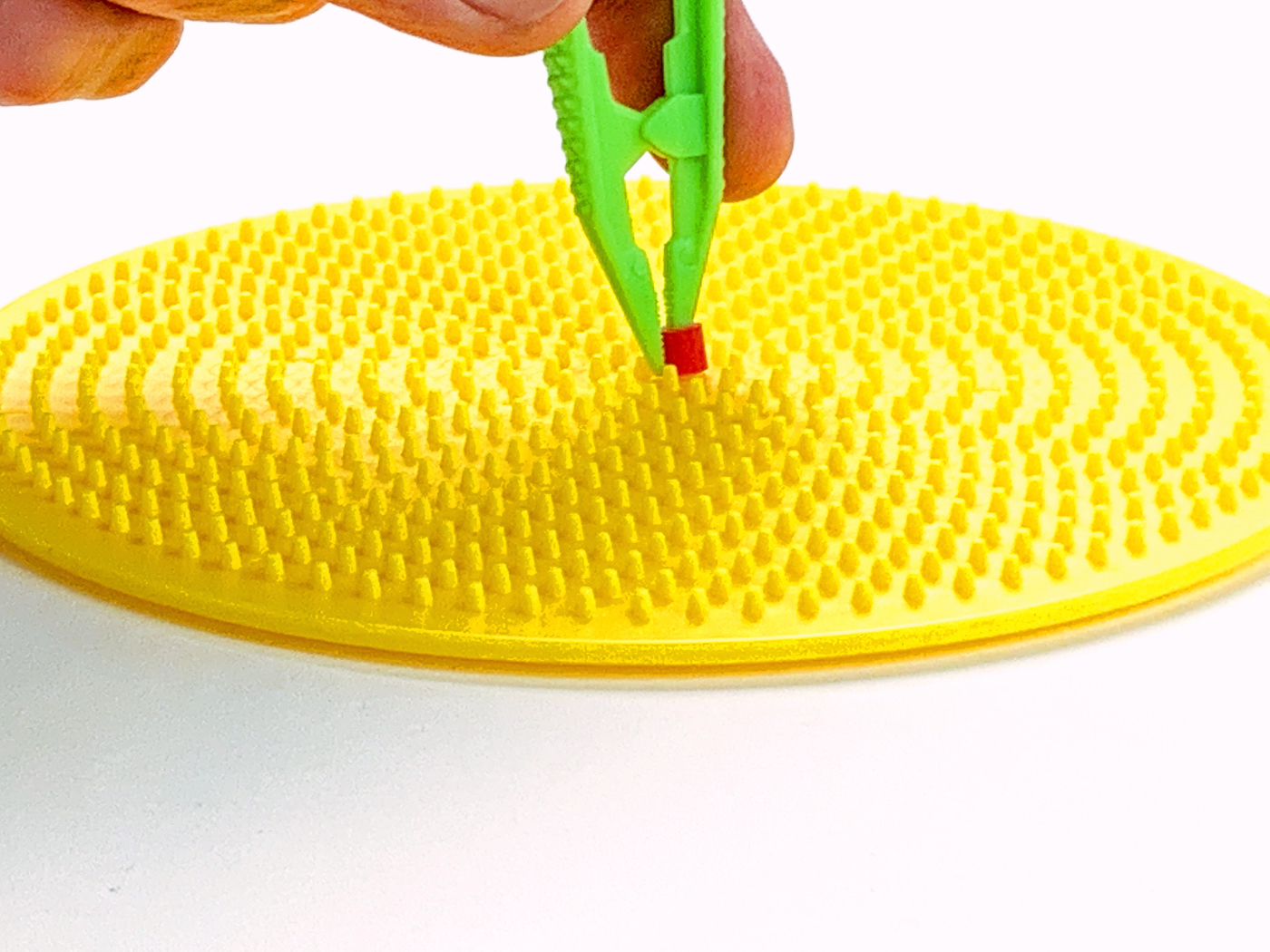 Placing a bead onto the pegboard with tweezers