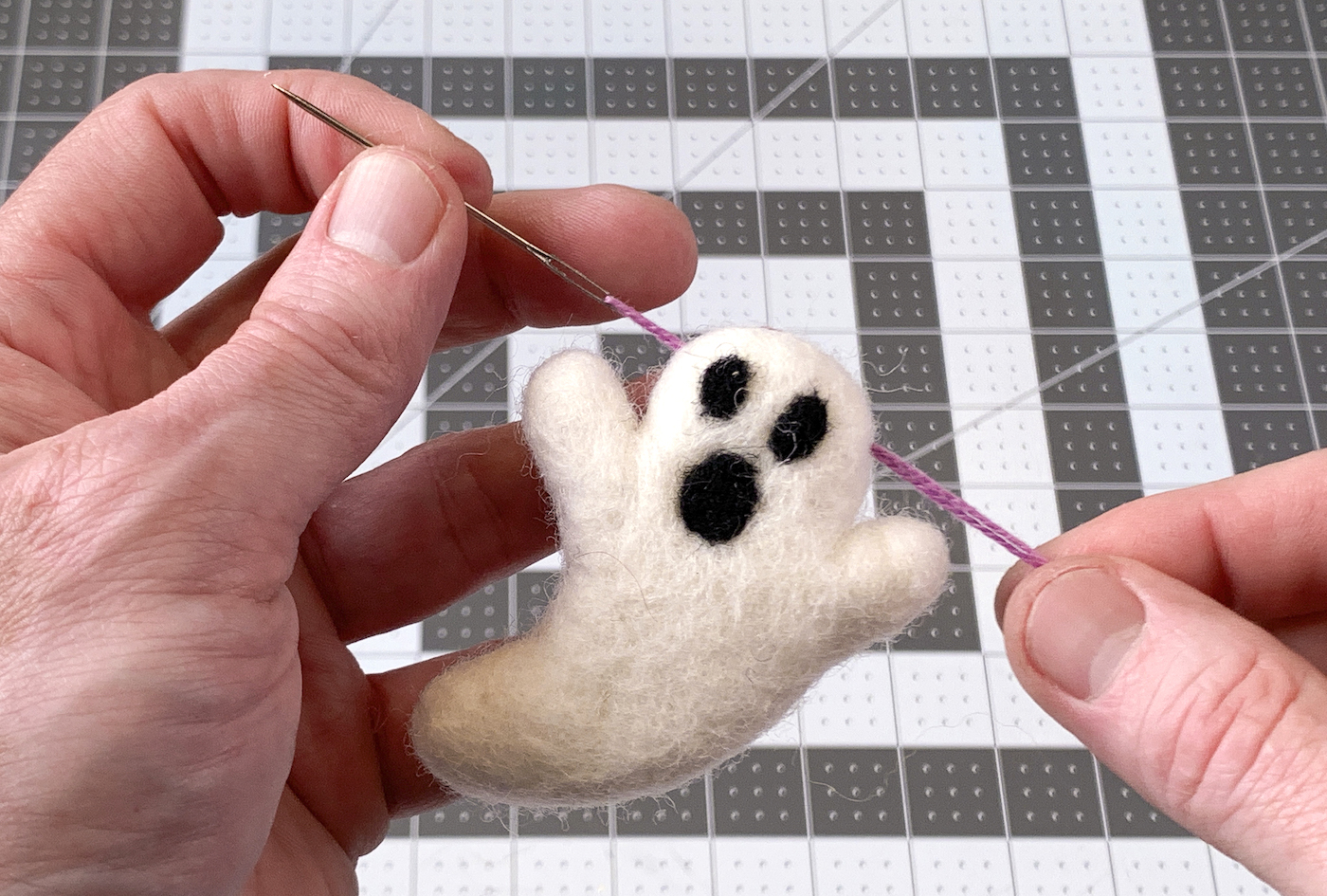 Stringing a felt ghost with purple embroidery floss