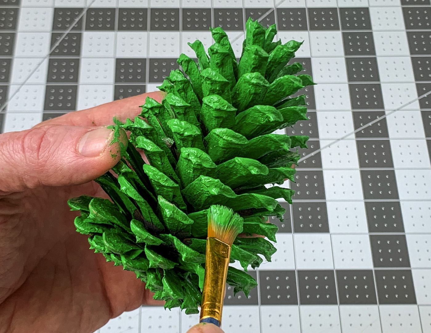 Touching up the pine cone with green paint
