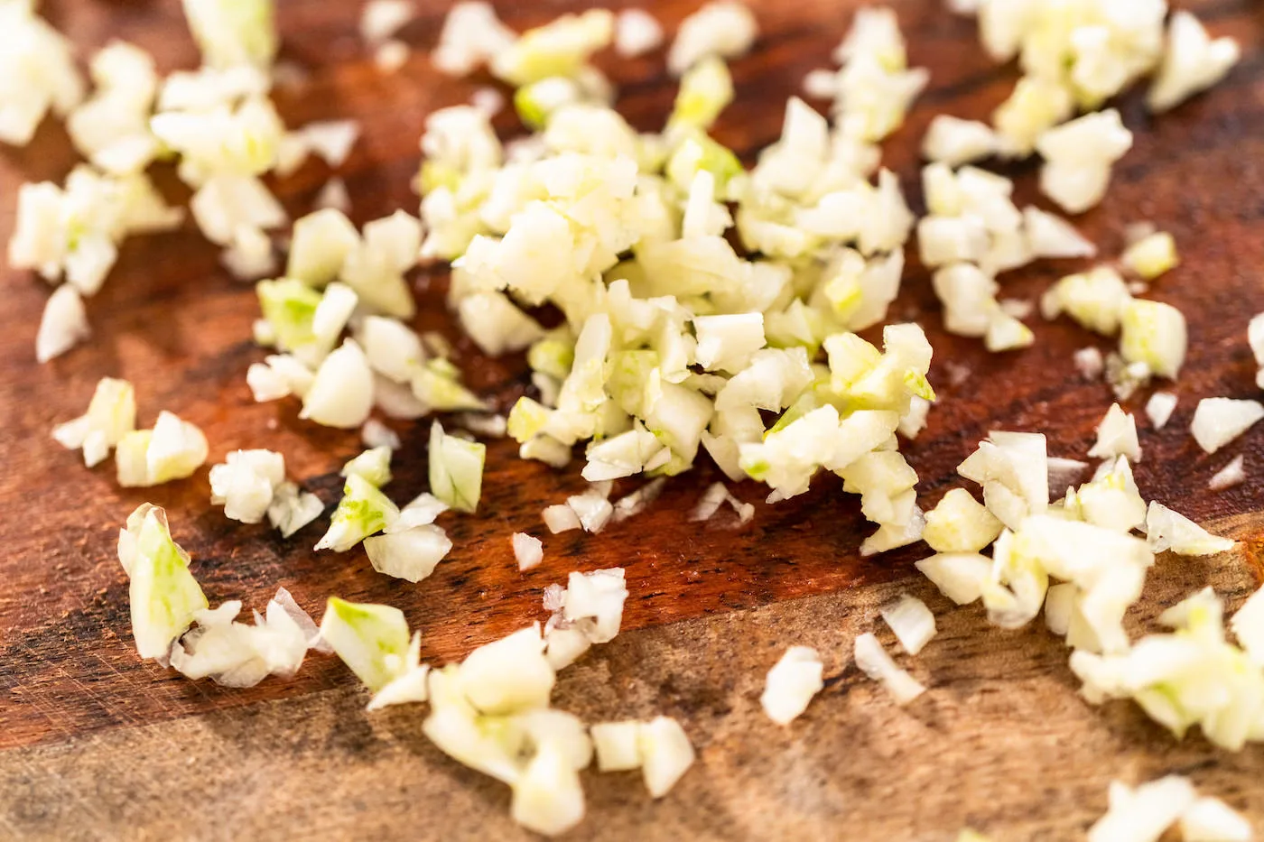 Mincing organic garlic on a wood cutting board