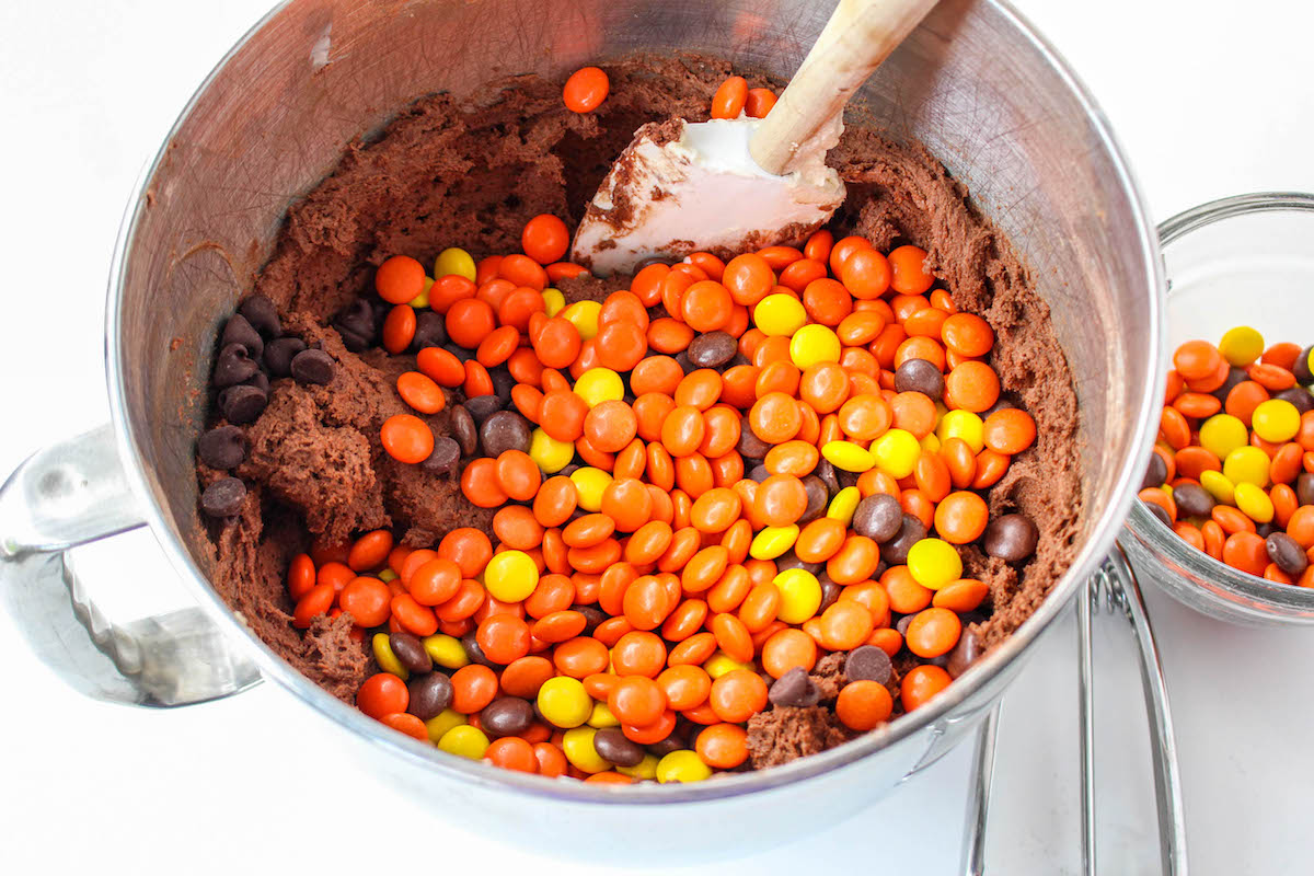 Adding Reese's pieces to the cookie batter