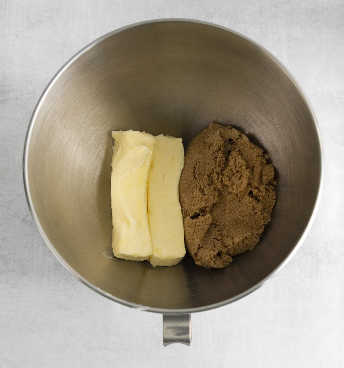 Two sticks of butter and brown sugar in a metal bowl