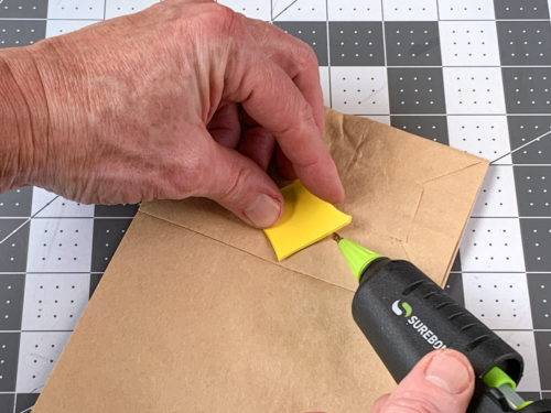 gluing the beak down to the paper bag