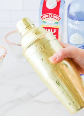 Woman's hand shaking a gold shaker