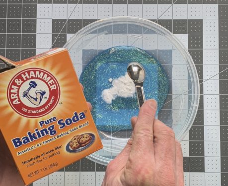 Adding baking soda to the glitter glue