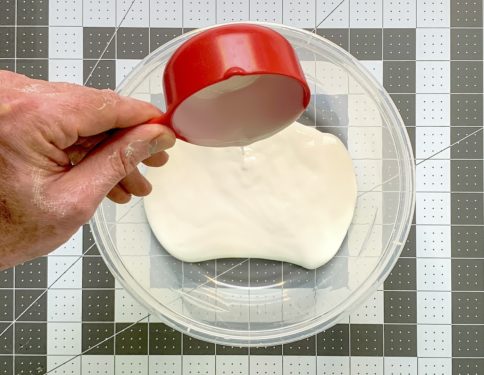 Pouring half a cup of glue into a container