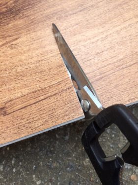 cutting vinyl flooring with utility scissors