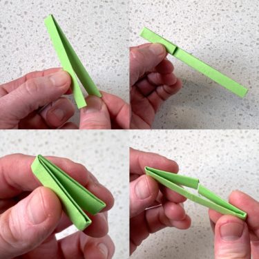 folding a long strip of green origami paper in half twice
