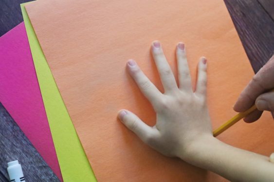 Tracing a child's hand on construction paper