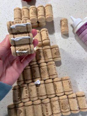 hand holding wine corks with glue on them