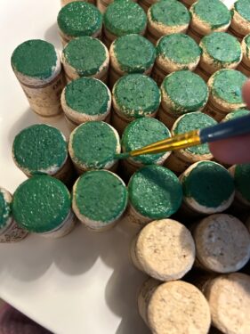 painting the edges of the corks with green paint