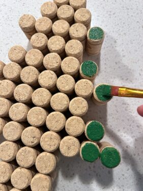 painting the ends of wine corks with green paint